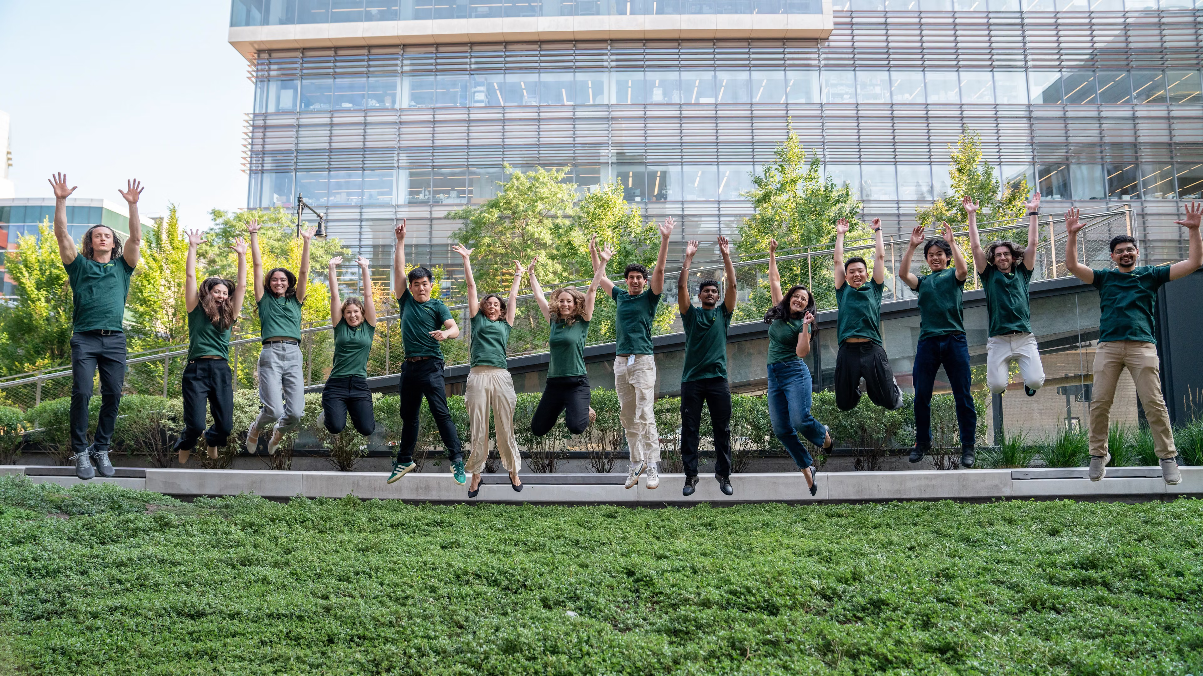 Brendon Smith and Transfyr colleagues jumping on the lawn outside The Engine, Cambridge, Massachusetts