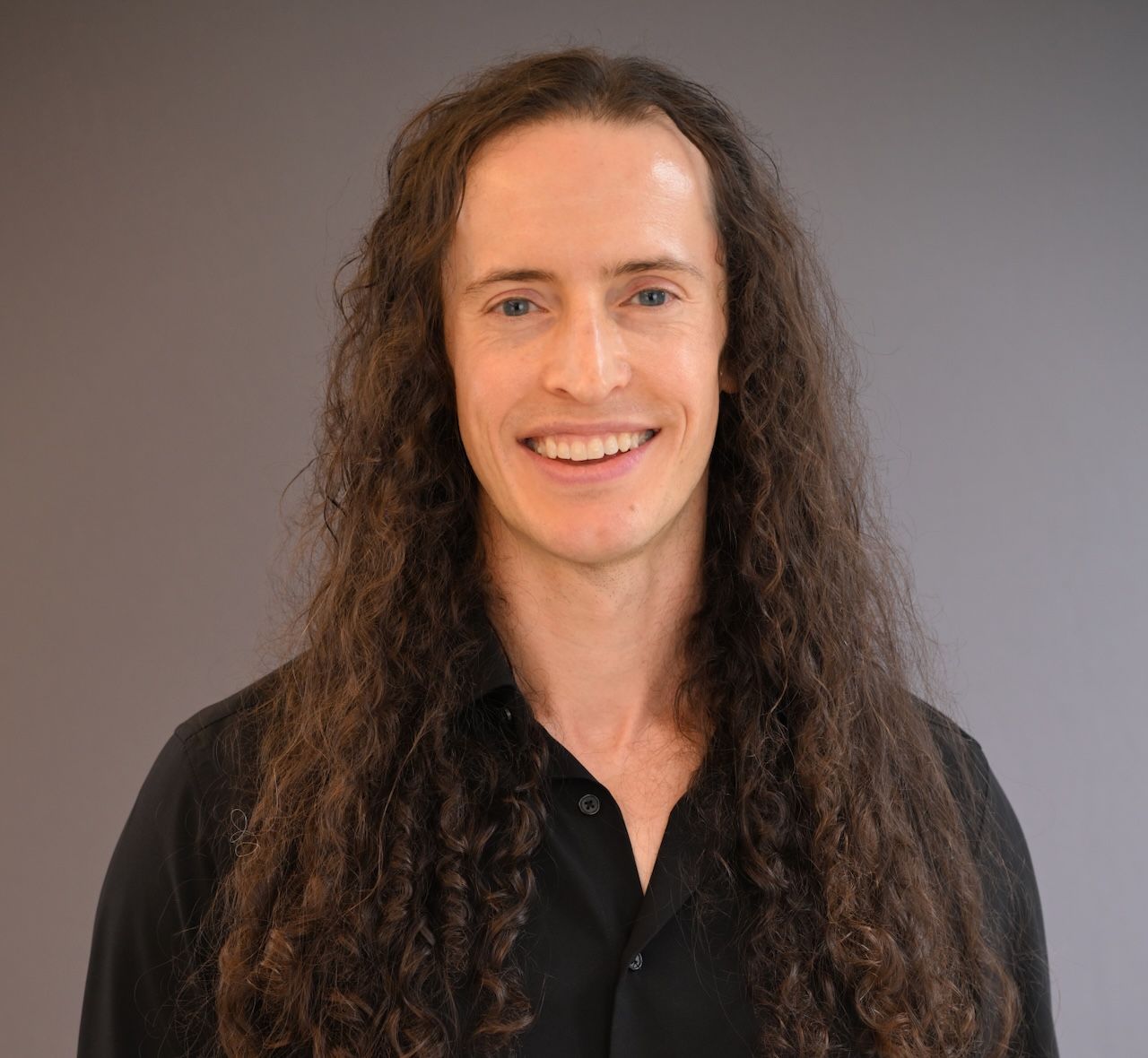 Portrait of Brendon Smith smiling in a black t-shirt