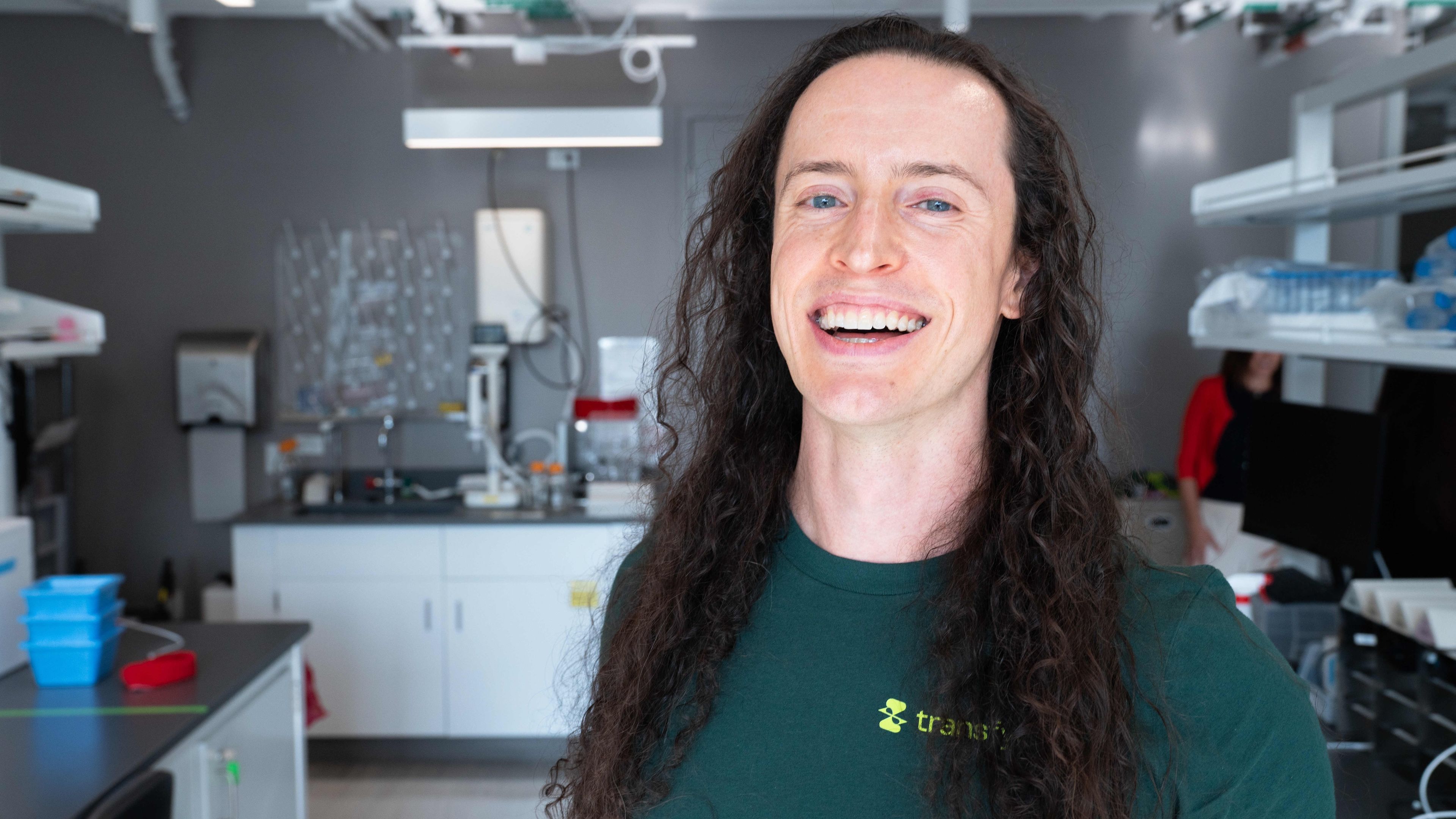 Portrait of Brendon Smith smiling in a Transfyr t-shirt in the Transfyr lab at The Engine, Cambridge, Massachusetts