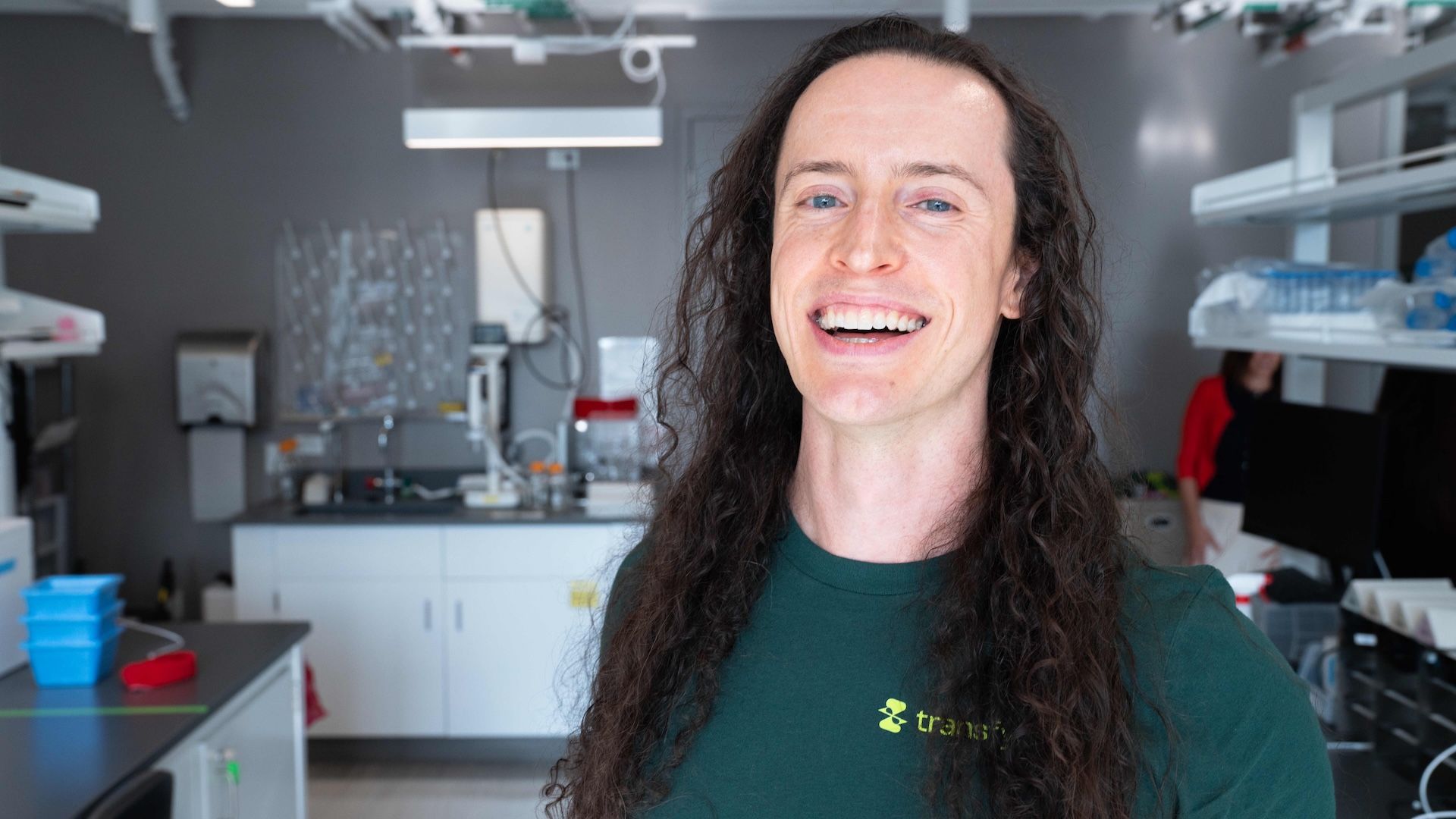 Portrait of Brendon Smith smiling in a Transfyr t-shirt in the Transfyr lab at The Engine, Cambridge, Massachusetts